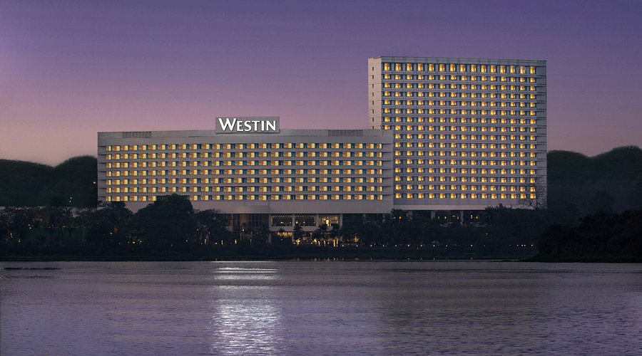 The Westin Mumbai Powai Lake at dusk — illuminated facade reflected across Powai Lake